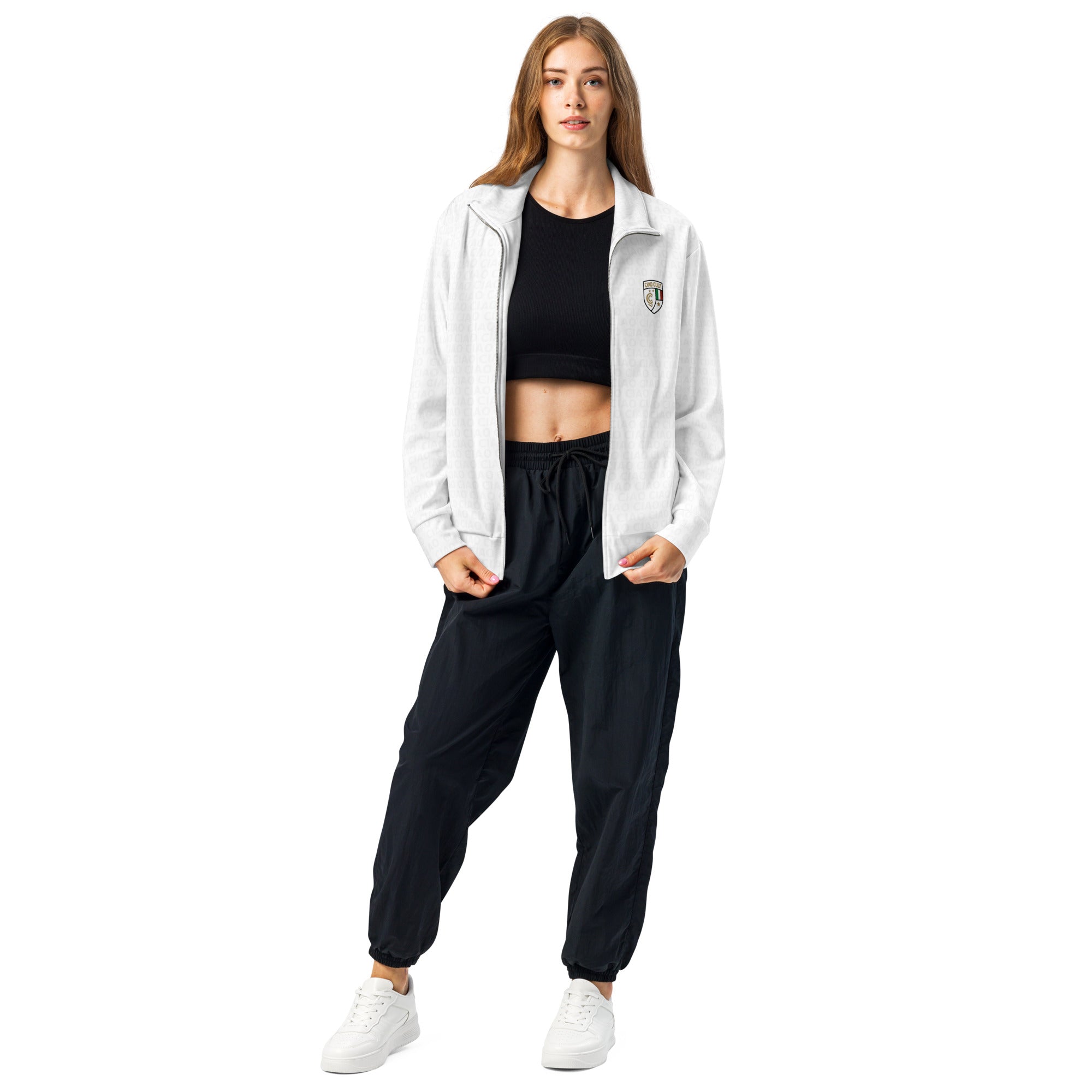 White zip-up track jacket with subtle crest logo on chest, worn over black crop top and black joggers. - Ciao Cult - 2XS