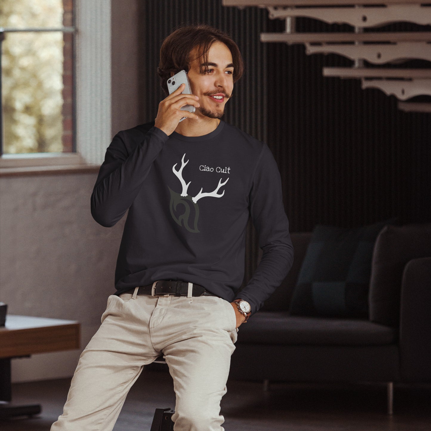 Male model talking on cellphone wearing Ciao Cult Antler Holiday Special Edition Long Sleeve Fitted Crew in heavy metal color.