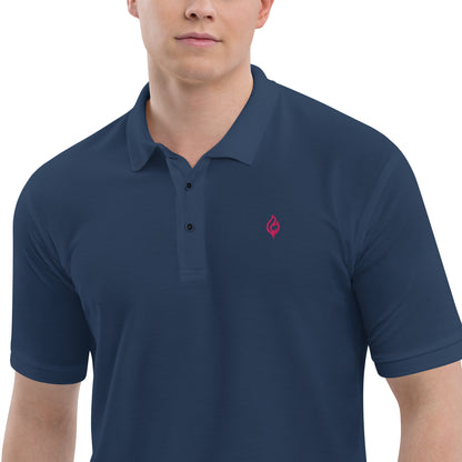 Close-up waist-to-jaw view of male model wearing Ciao Cult Men’s Signature Flame Polo in navy with flamingo-pink flame emblem.