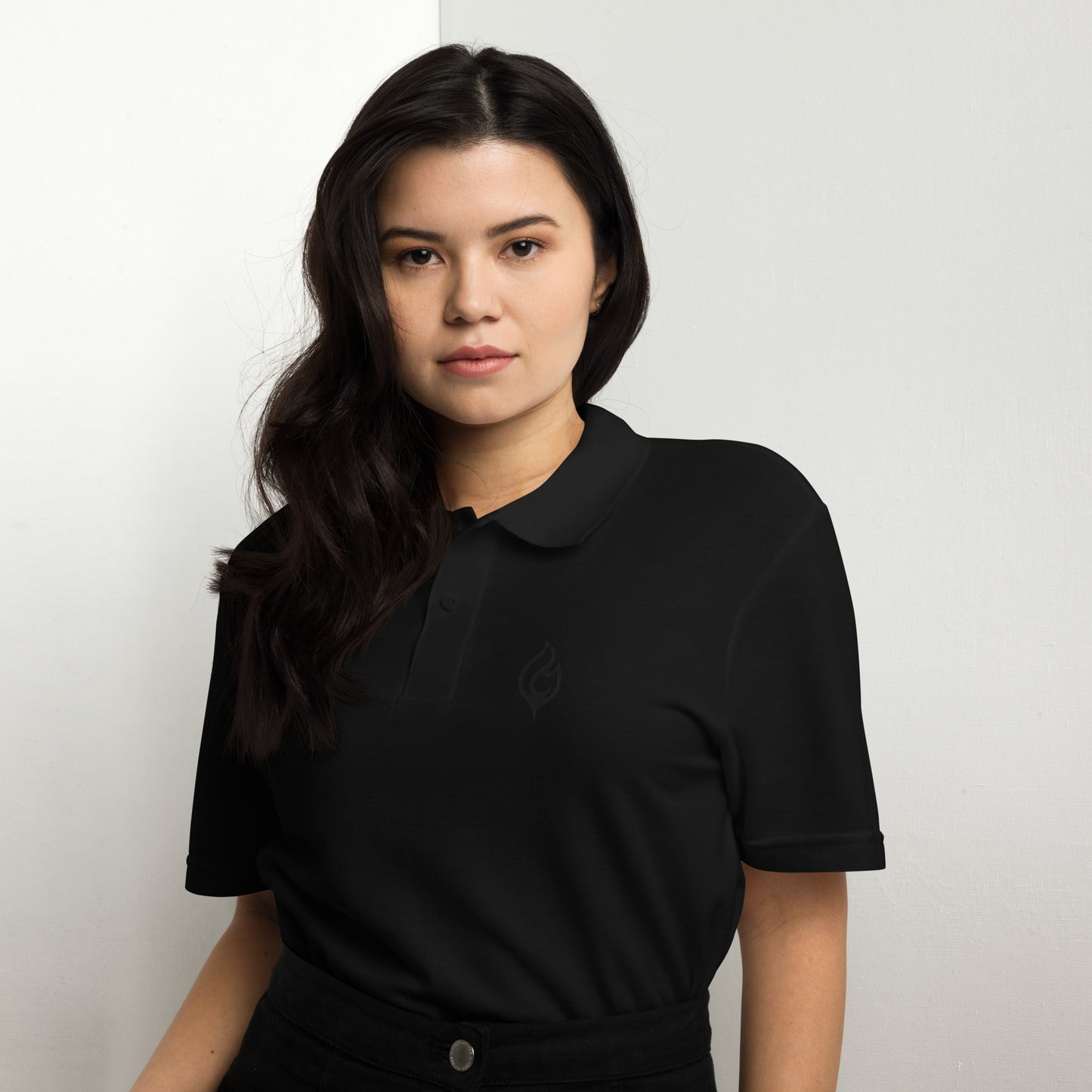 Female model waist-up front view wearing Ciao Cult Tonal Black-on-Black Signature Flame Polo, minimalist streetwear style.